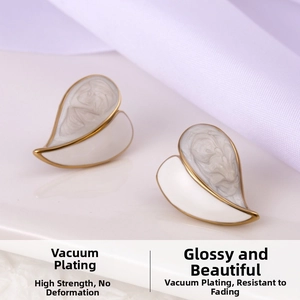 Macro detail of heart-shaped earrings with marble texture and gold plated edges