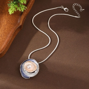 Macro detail of enamel rose pendant with blue finish and pearl on silver snake chain