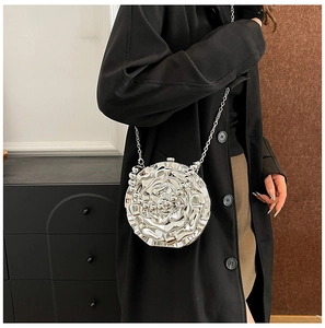 Silver flower-shaped 3D rose chain bag worn as a shoulder bag on a black wool coat