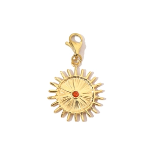 Detail of a golden sun pendant with an orange gemstone and functional lobster clasp