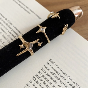 Macro shot of gold star-shaped ring set with zircon on black velvet stand over book
