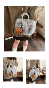 Close-up of fluffy grey plush handbag with woven white handles and a cute teddy bear charm