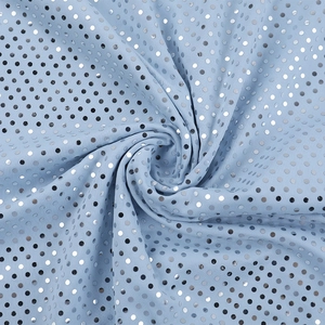 Detail aus hellblauem Paillettenstoff mit silbernen Punkten und elegantem Faltenwurf