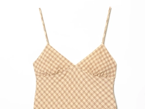 Detail of plaid dress showing the V-neckline, spaghetti straps, and pleated bust texture