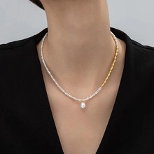 Detail of elegant natural pearl necklace featuring gold beads and a teardrop pearl pendant