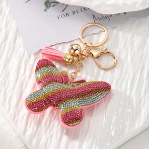 Detail of butterfly keychain with colorful rhinestones, golden chain and pink tassel