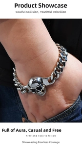 Close-up of a silver punk skull bracelet on wrist with heavy curb chain style links