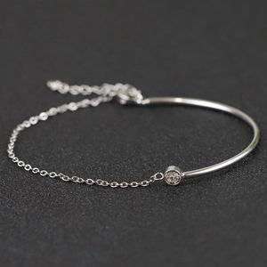 Macro shot of silver stainless steel chain bracelet with a central round zircon stone