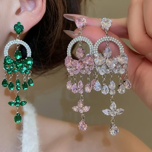 Detail of luxury teardrop tassel earrings with emerald, pink, and clear crystal stones
