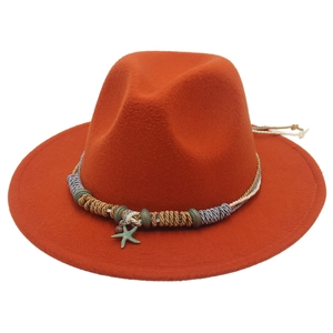 Dettaglio cappello in feltro arancione con fascia intrecciata e ciondolo a stella