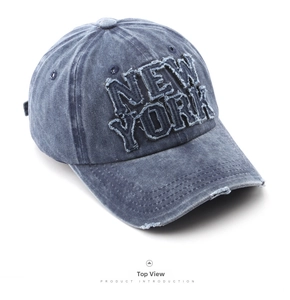 Detail of vintage navy denim baseball cap featuring New York patch and distressed brim