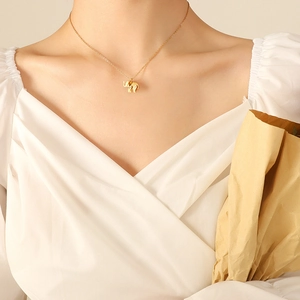 Elegant 18K gold plated elephant pendant necklace worn by a model on white V-neck top