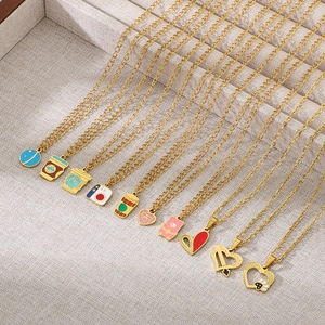 Vue détaillée des chaînes dorées avec pendentifs en émail coloré, café et appareil photo
