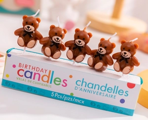 Macro shot of 5 cute brown teddy bear birthday candles with bow ties for cake decoration