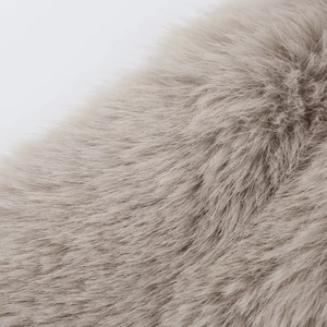 Close-up detail of soft light brown faux fur texture with fluffy loose synthetic fibers