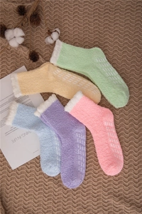 Detail of coral fleece socks with anti-slip silicone grippers on warm macaron colors
