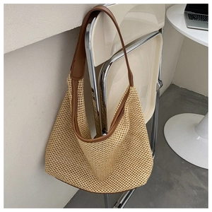 Detail of woven mesh hollow bag with brown faux leather trim and shoulder strap