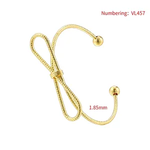 Detail of 1.85mm thick gold-plated twisted bow bangle with elegant snake texture