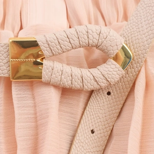 Chic beige snakeskin texture belt with gold buckle on a pleated midi dress
