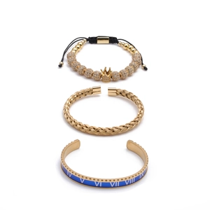 Golden crown beads, braided cuff and blue Roman numeral bangle set on white background