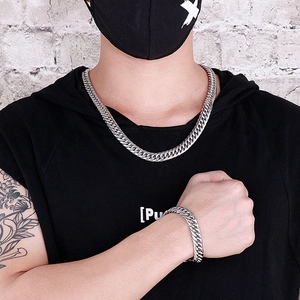 Street style view of men wearing silver stainless steel Cuban link necklace and bracelet