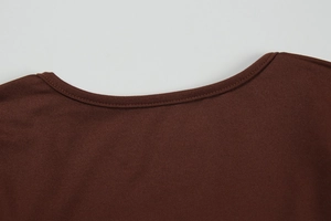Detail of a deep brown knitted dress showing the round neckline and stitching