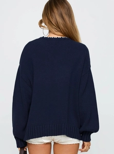 Back view of a loose navy knit sweater showing shoulder details and texture