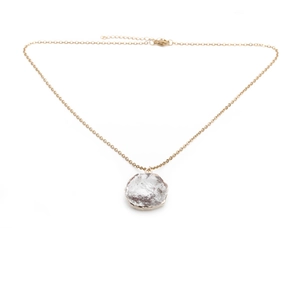 Detail of minimalist gold chain necklace with an irregular translucent crystal pendant