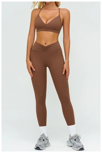 Dettaglio del reggiseno sportivo marrone con scollo a V e leggings a vita alta con pieghe a V