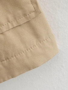 Detail of khaki canvas fabric showing double stitching texture and high-quality craftsmanship
