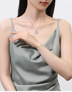 Close-up of S925 silver necklace with oval blue stone and diamond halo on model