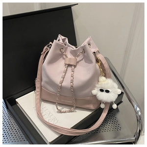 Detail of pink and purple bucket bag with metal chain closure and fluffy pendant