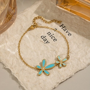 Detail of gold chain bracelet with turquoise enamel flowers and small crystals