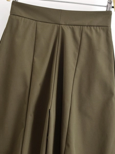Detailed close-up of high-waist military green wide-leg trousers with elegant pleats