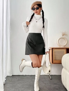 Fashionable look with black matte leather A-line skirt and white turtleneck knit sweater