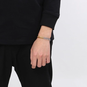 Close-up of hip hop two-tone gold and silver NK link chain bracelet with OT buckle on wrist
