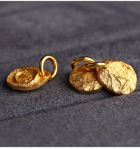 Macro shot of three gold-plated S925 silver lotus pendants with irregular textures
