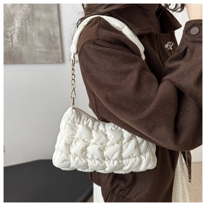 Close-up of white quilted bubble shoulder bag with a stylish gold metal chain strap