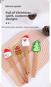Set of four Christmas silicone spatulas with wooden handles on a rustic tray