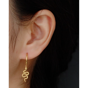 Close-up of S925 sterling silver golden snake drop earrings worn by a female model