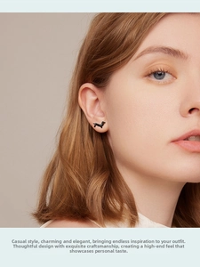Close-up of a model wearing a black dachshund puppy stud earring in s925 silver finish