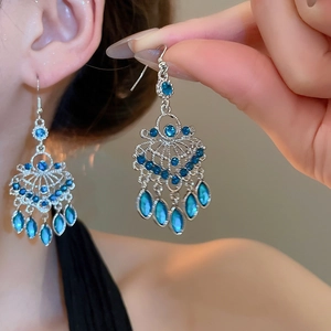 Close-up of vintage butterfly earrings featuring mint blue stones on silver finish