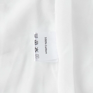 Detail shot of the garment care label showing 100% Cotton material and washing symbols