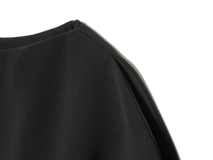 Vue macro des coutures précises et du tissu noir de haute qualité des manches bouffantes