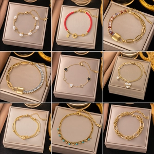 Golden titanium steel jewelry set with pearls, hearts and Roman numerals on display
