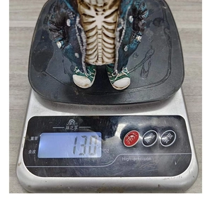 Detailed view of resin Sans skeleton figurine on a digital scale showing 130g weight