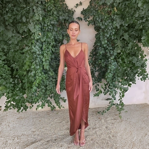 Robe longue en satin rouge rouille avec col en V et nœud à la taille en décor extérieur