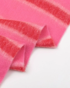 Detail of pink striped scarf showing thick bouclé yarn texture and soft fuzzy material