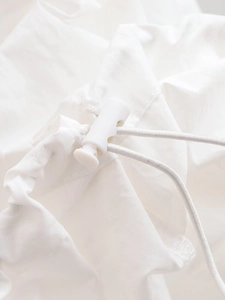Détail du cordon élastique blanc et du fermoir en plastique sur le tissu technique