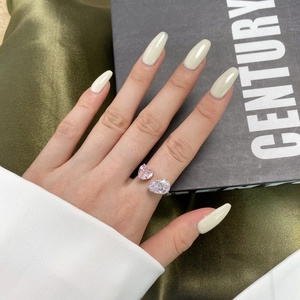 Detailed view of an open ring featuring pink heart and white pear-cut zircon stones